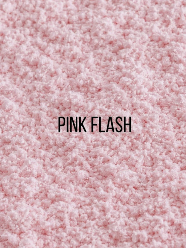 A close-up texture shot of a fluffy pink faux fur or sherpa fabric, with the text &