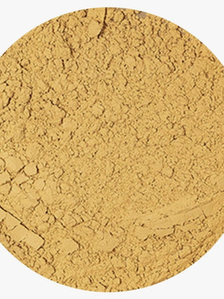 A close-up circular view of a fine, textured golden-yellow powder, likely cosmetic powder or pigment, on a white background.