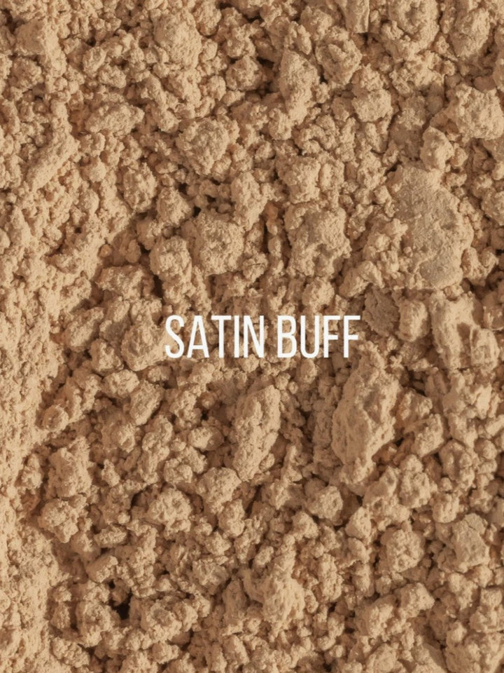 A close-up texture shot of a light tan/beige powder labeled &