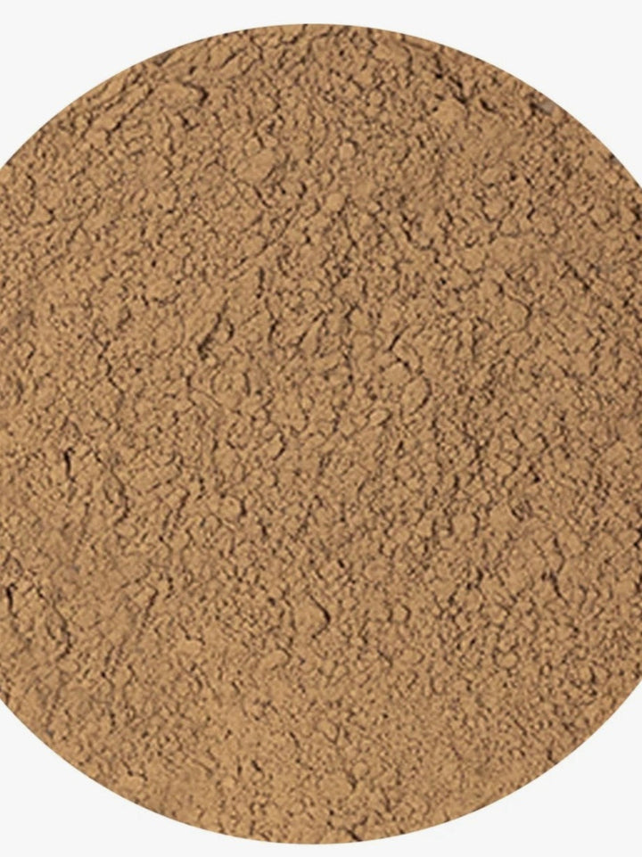 A close-up circular texture swatch of a fine brown powder, likely cosmetic or food-grade, on a plain white background.