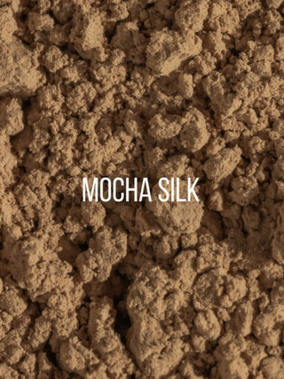A close-up texture shot of a brown, crumbly powder labeled with the text 'MOCHA SILK' in white sans-serif font across the center.