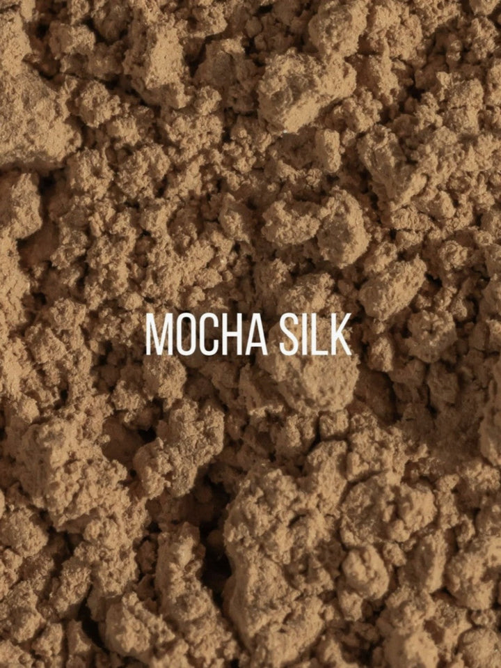 A close-up texture shot of a brown, crumbly powder labeled with the text &