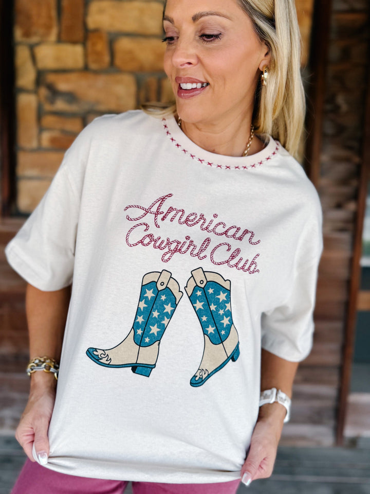 A woman wearing a white graphic t-shirt with &