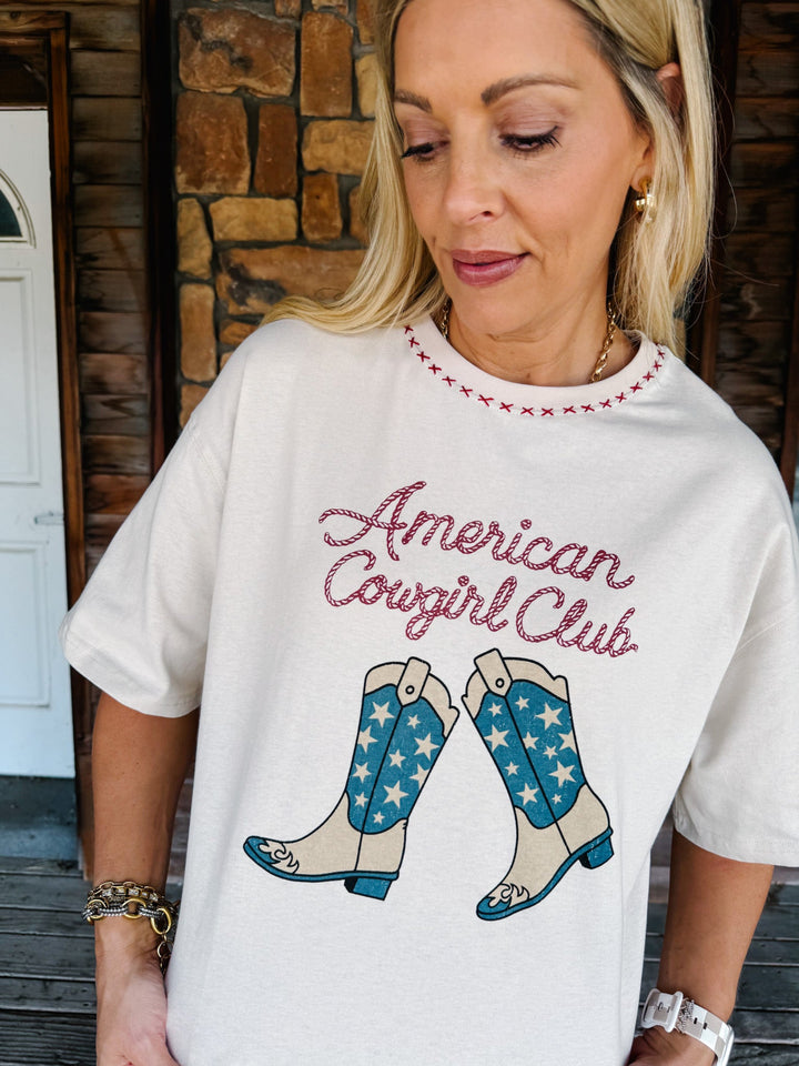 A woman wearing a white graphic t-shirt with &