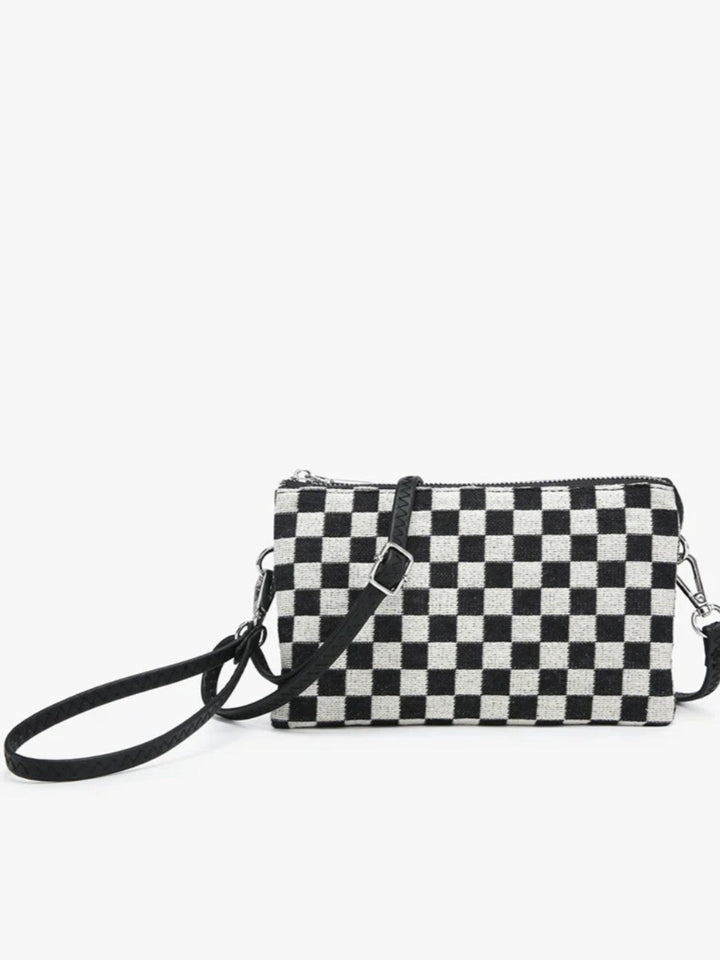 A small black and white checkered crossbody clutch bag with a black wrist strap and silver-tone hardware, shown against a plain white background.
