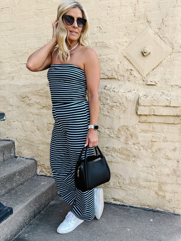 Model wearing the Boardwalk Strapless Stripe 2pc Set in navy and sky, with a yellow wall background.