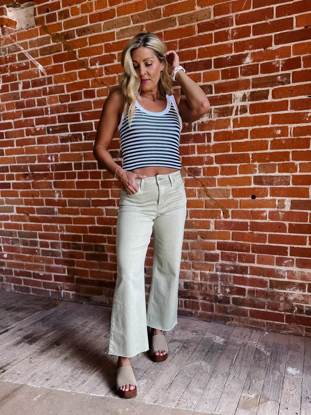 Model wearing olive wide leg crop jeans with a striped top and sandals.