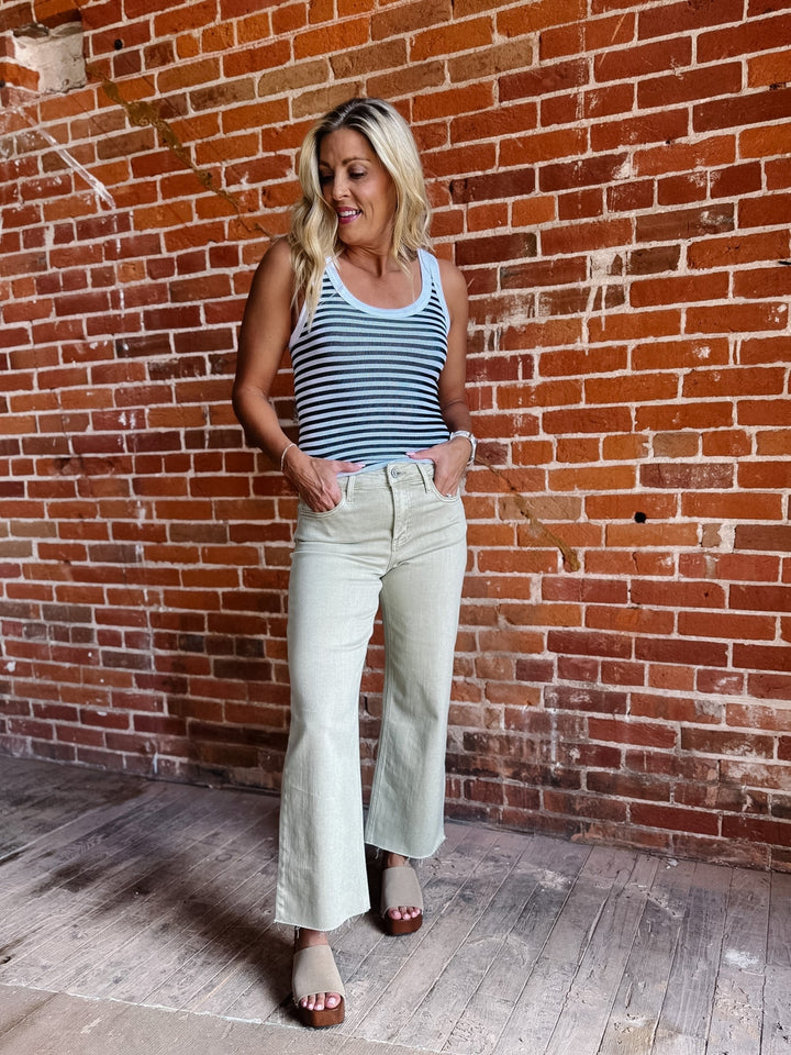 Model wearing olive wide leg crop jeans with a striped top and sandals.