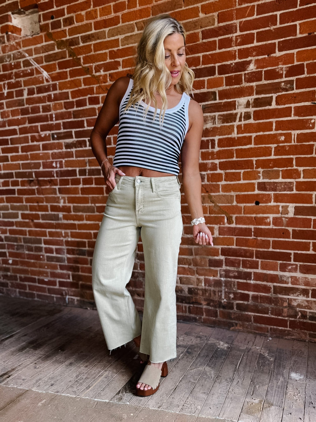 Model wearing olive wide leg crop jeans with a striped top and sandals.