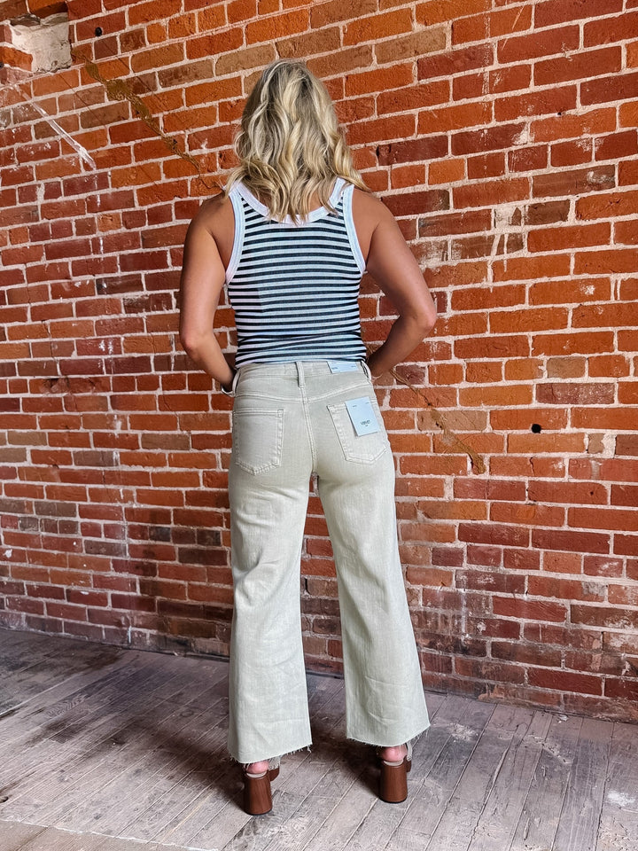 Model wearing olive wide leg crop jeans with a striped top and sandals.