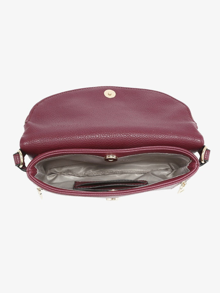 A burgundy pebbled leather crossbody bag shown from a top-down view, with its front flap open to reveal a gray interior lining and a gold-tone snap button closure.