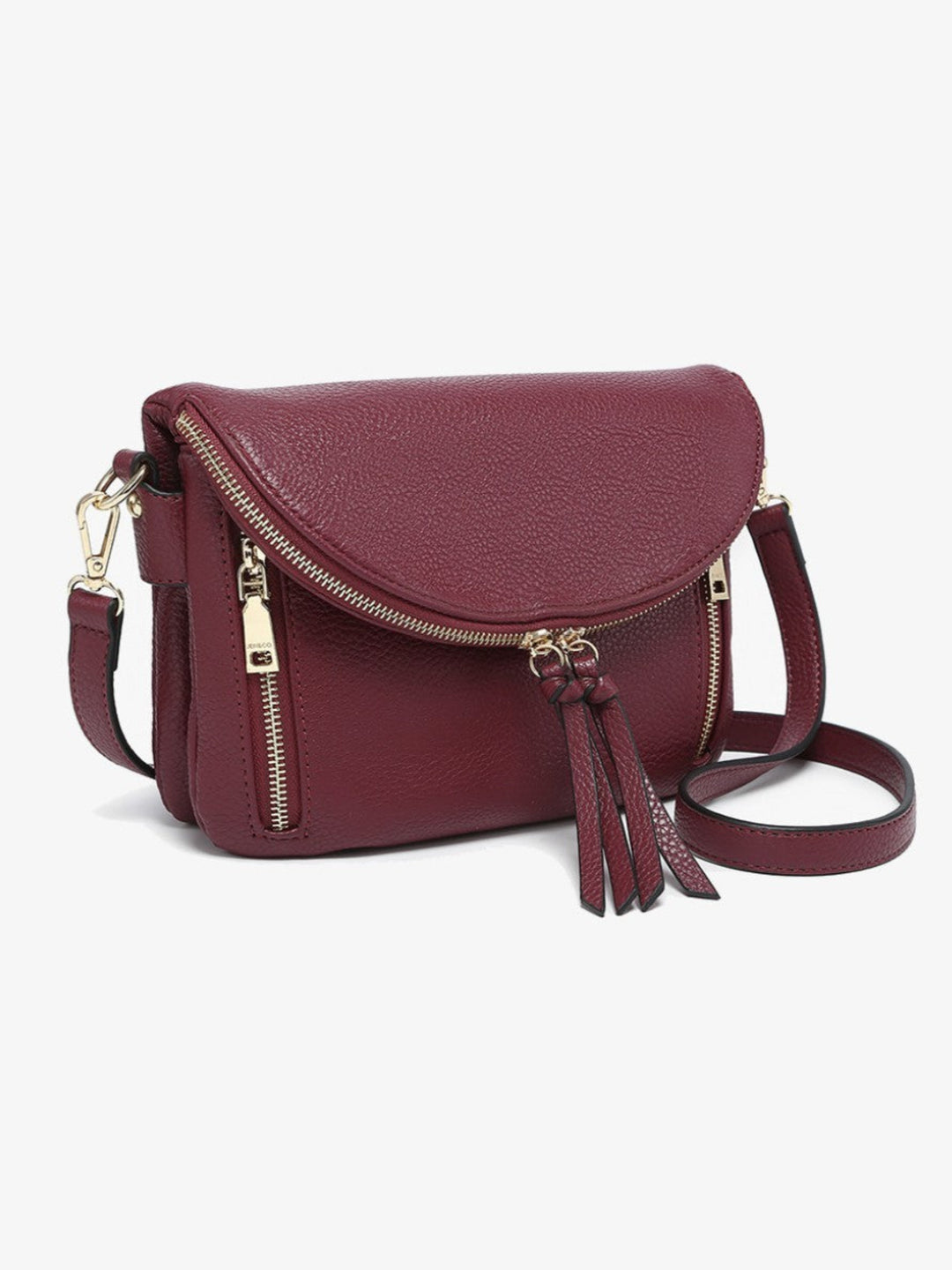 A burgundy pebbled leather crossbody bag with gold-tone hardware, featuring a front flap, two zippered pockets, and a matching leather tassel detail, shown on a light gray background.