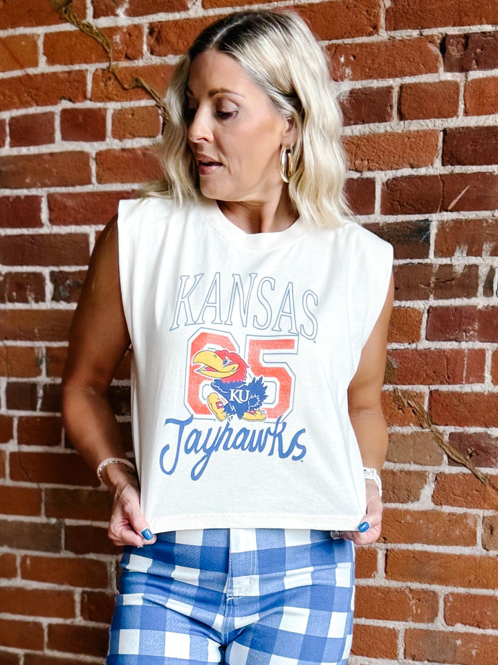 A woman wearing a white sleeveless crop top with a blue and red &