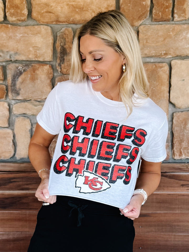 A woman wearing a white graphic t-shirt with &