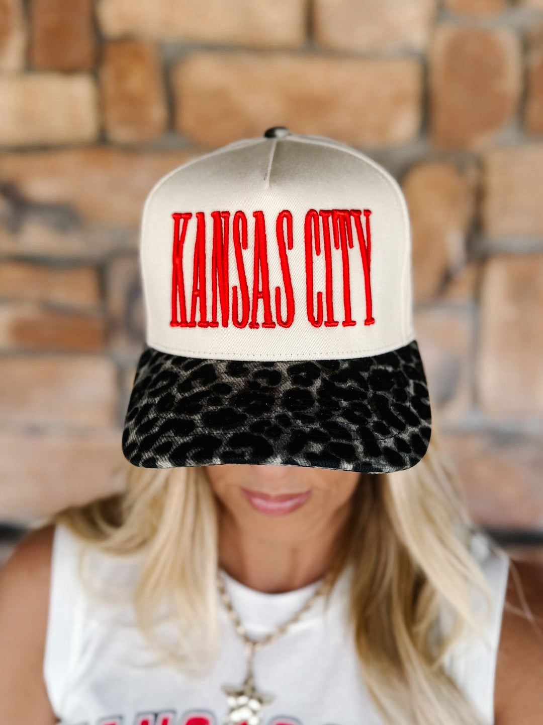 A woman wearing a snapback cap with a cream crown, red &