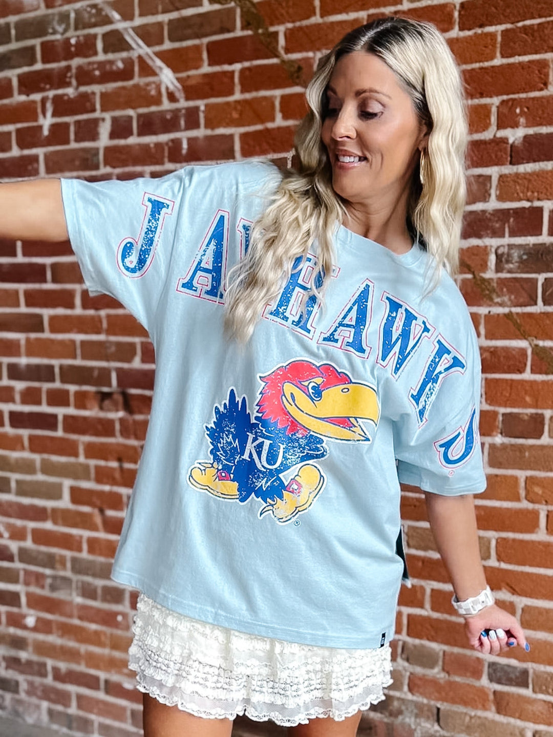 A woman wearing an oversized light blue graphic t-shirt with &
