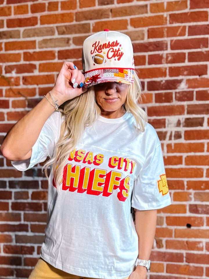 A woman wearing a white graphic t-shirt and a matching white &