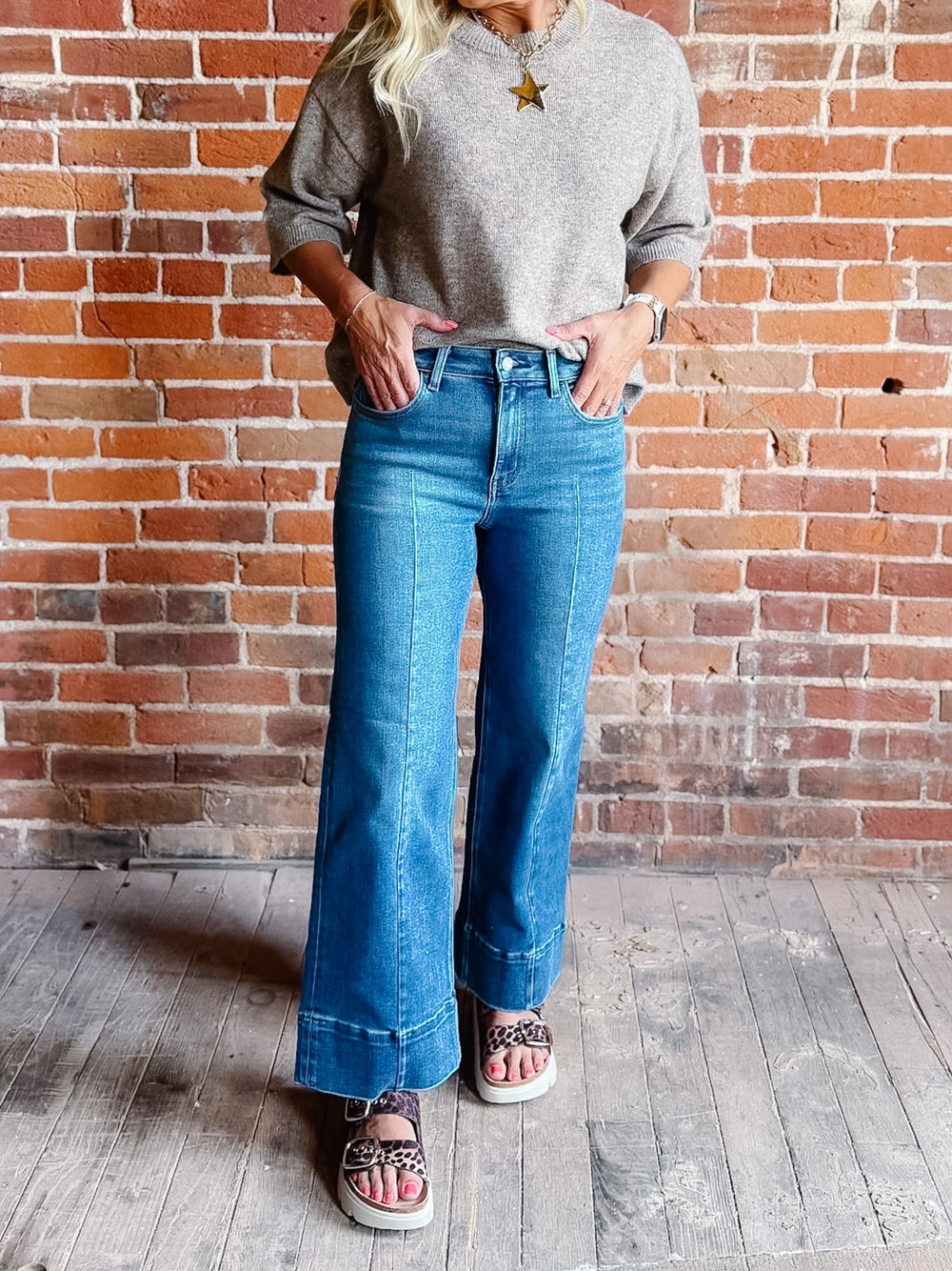 Wide leg jeans in medium dark wash with pintuck front detail and high-rise fit.