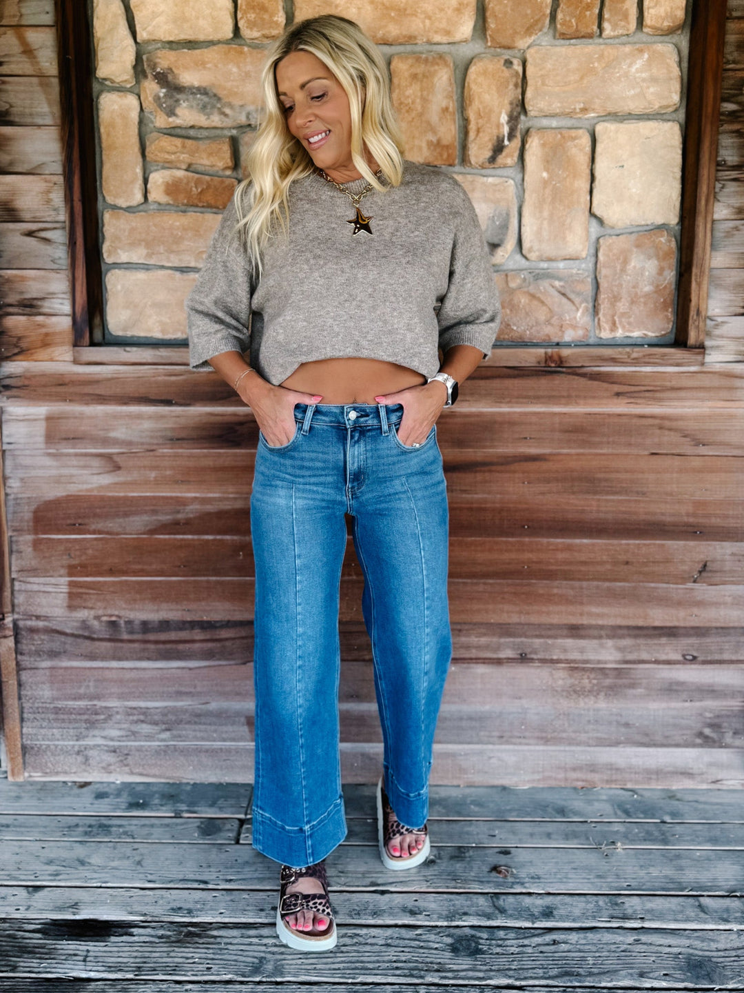 Wide leg jeans in medium dark wash with pintuck front detail and high-rise fit.