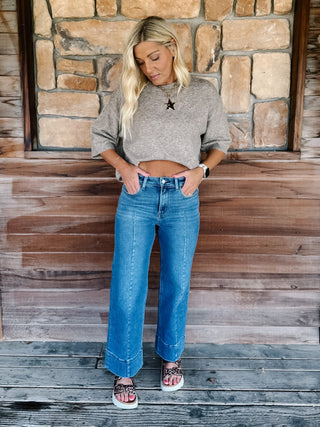 Wide leg jeans in medium dark wash with pintuck front detail and high-rise fit.