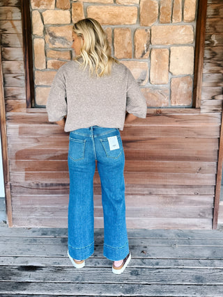 Wide leg jeans in medium dark wash with pintuck front detail and high-rise fit.