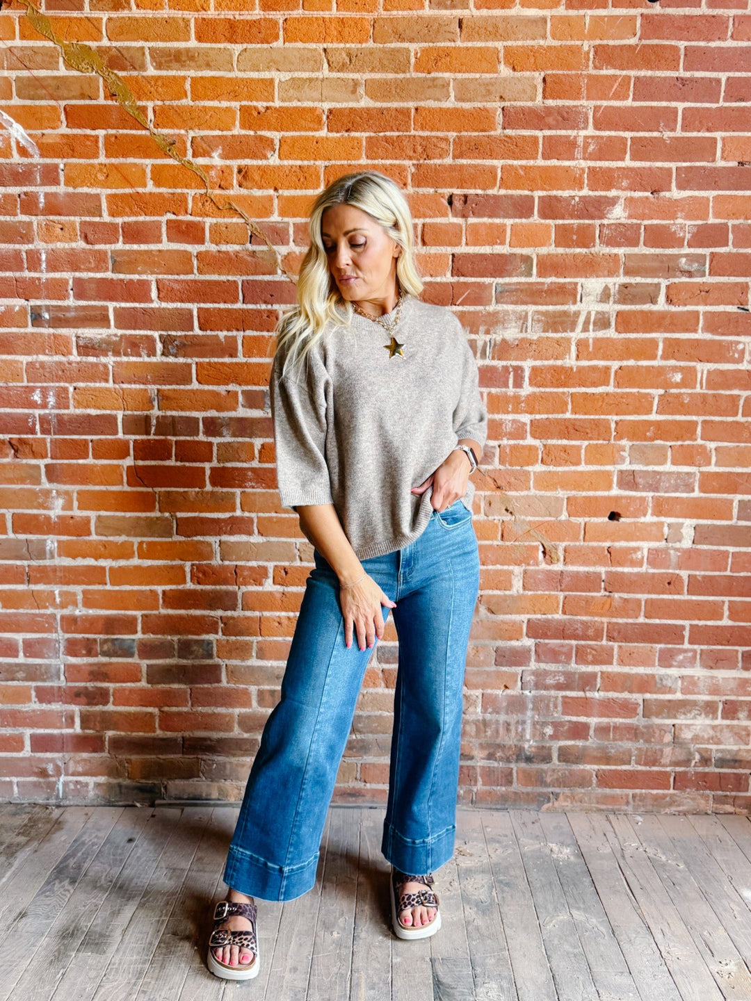 Woman wearing an oatmeal heathered half sleeve sweater with a relaxed fit and crew neckline.