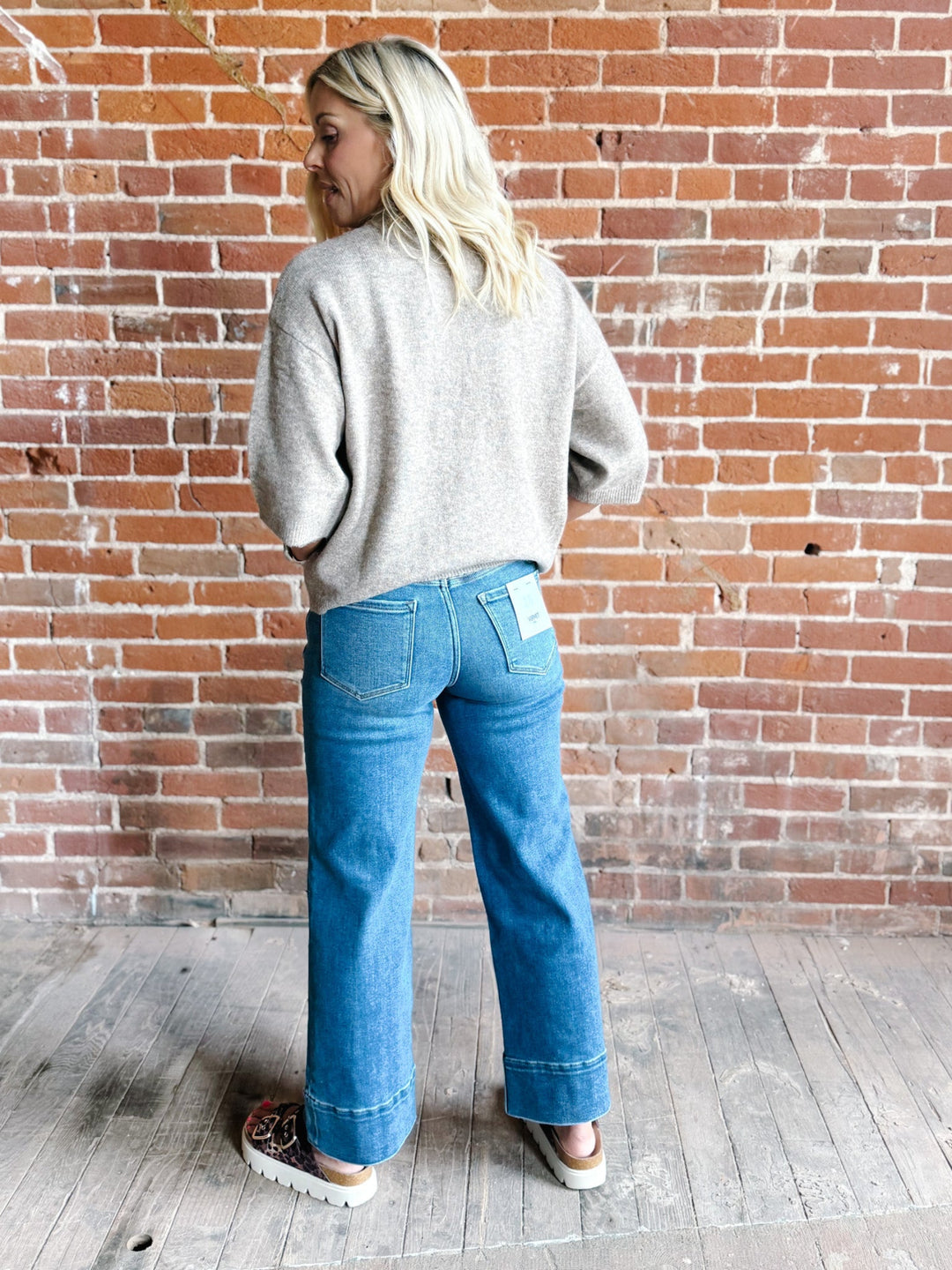 Woman wearing an oatmeal heathered half sleeve sweater with a relaxed fit and crew neckline.