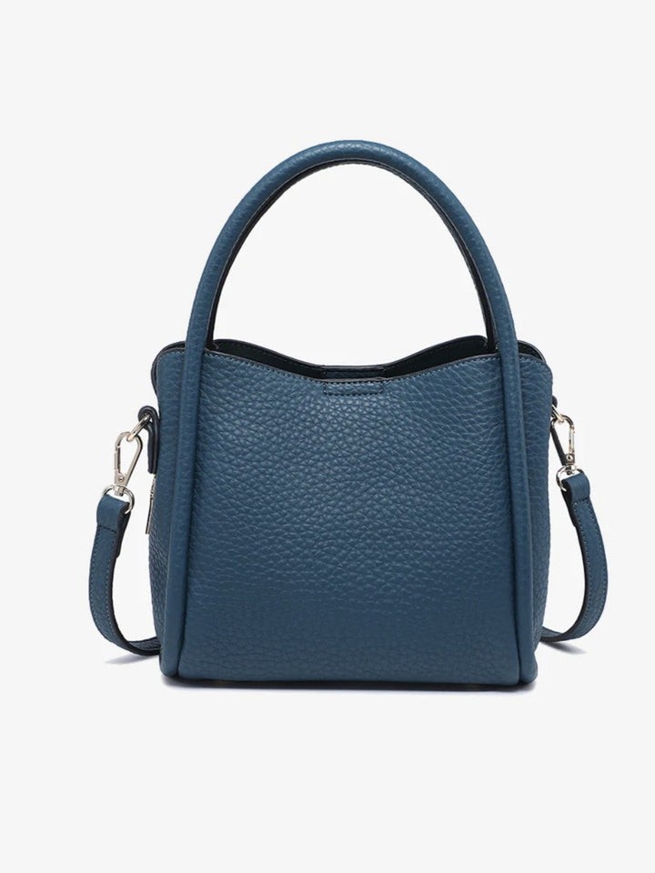 A blue pebbled leather handbag with a top handle and a detachable shoulder strap, shown against a plain white background.