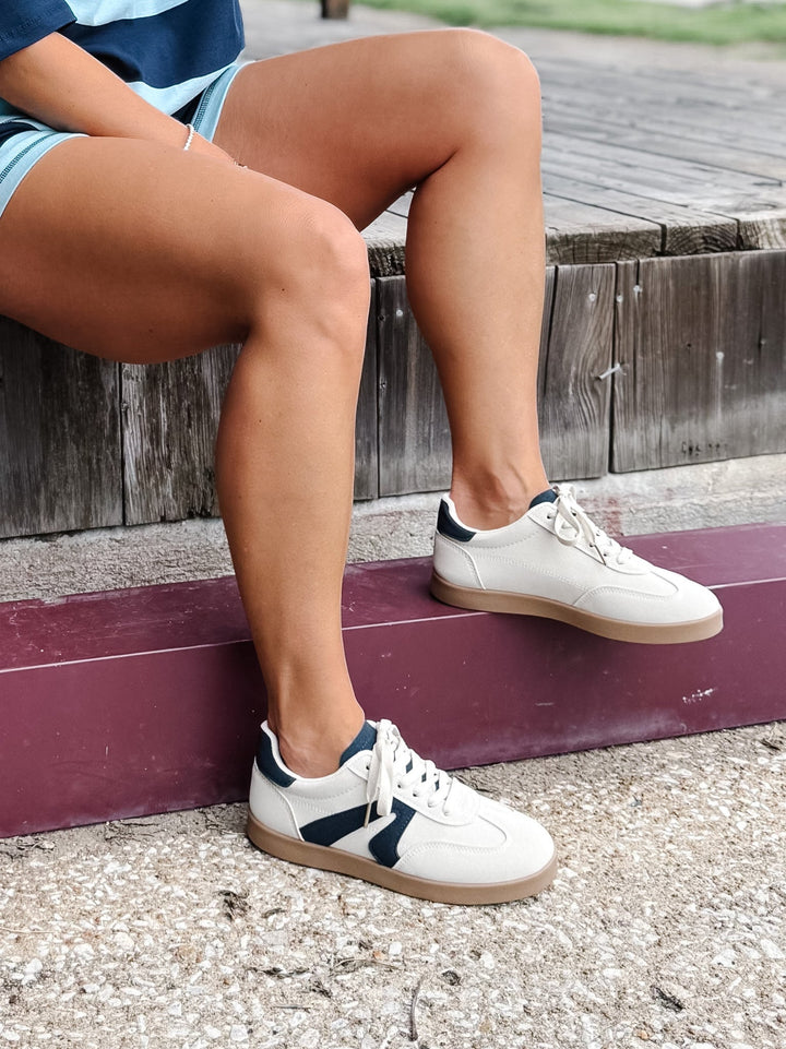 Retro sneaker in beige and navy with a lace-up closure and cushioned footbed, shown with stripe set