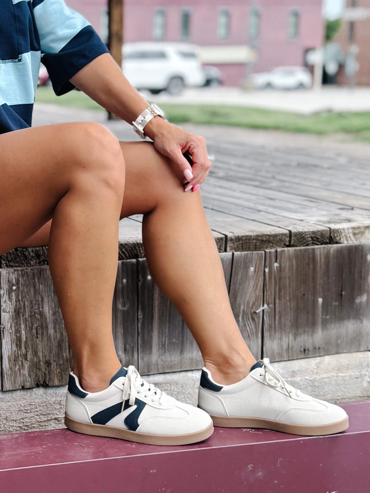 Retro sneaker in beige and navy with a lace-up closure and cushioned footbed, shown with stripe set
