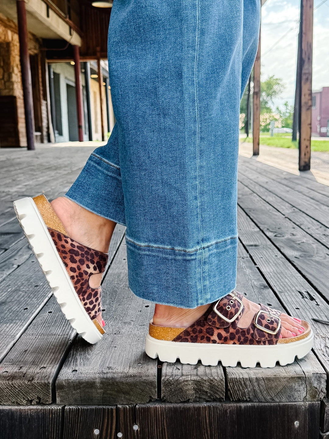 Leopard print sandals with chunky white platform sole and adjustable buckle straps.
