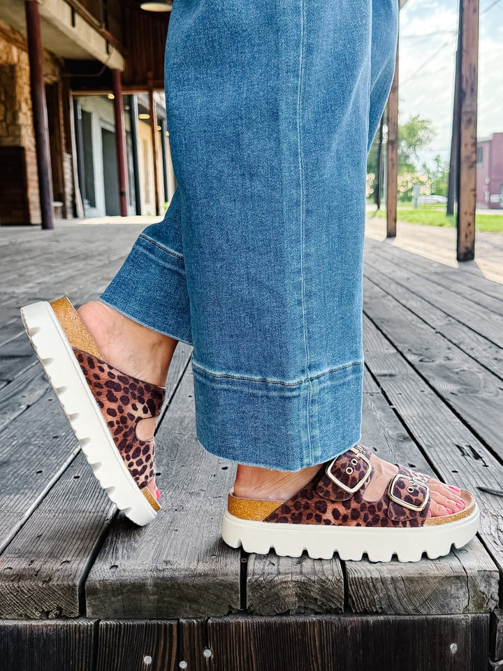 Leopard print sandals with chunky white platform sole and adjustable buckle straps.
