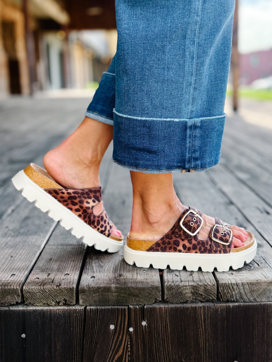 Leopard print sandals with chunky white platform sole and adjustable buckle straps.