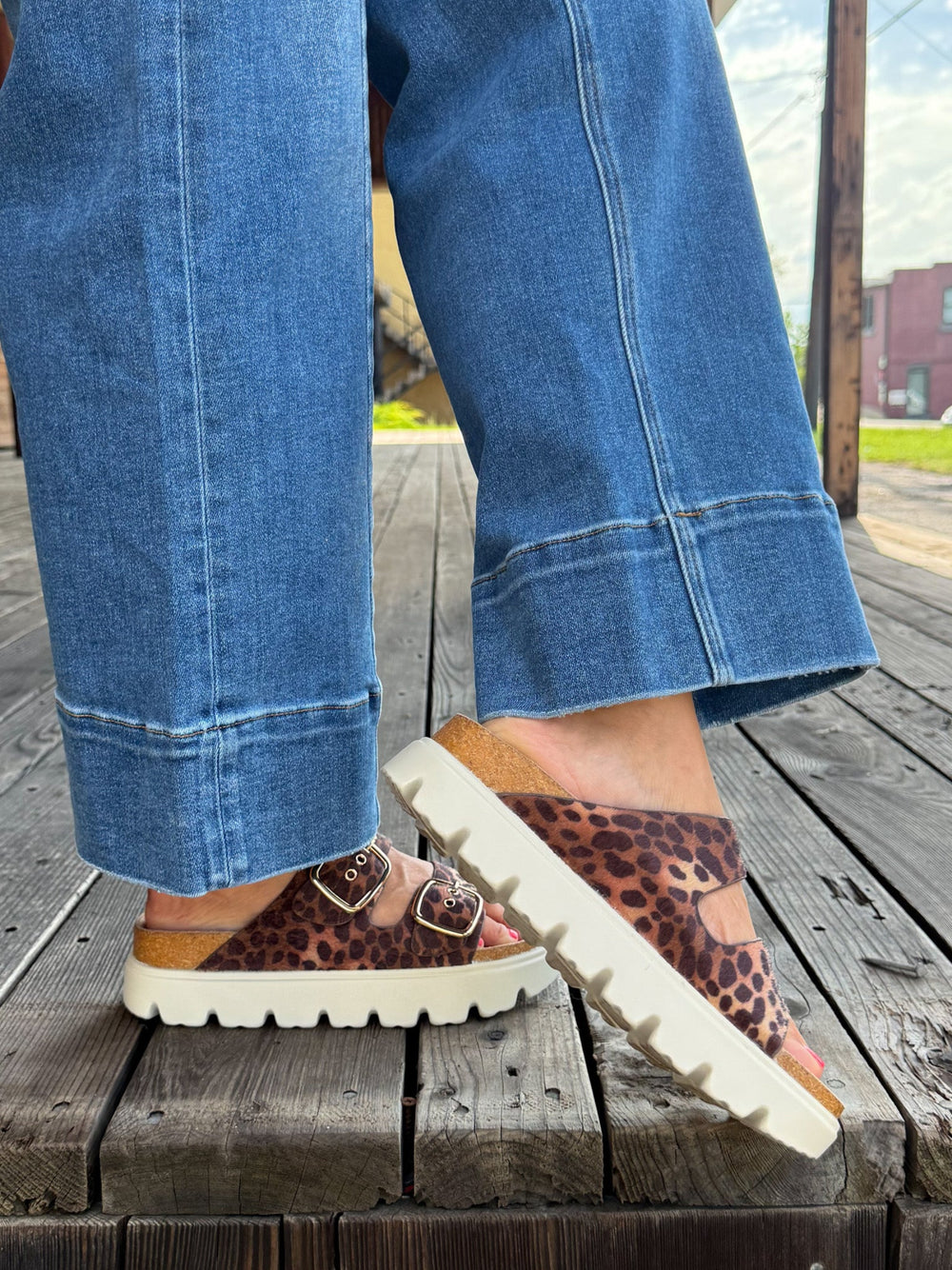Leopard print sandals with chunky white platform sole and adjustable buckle straps.