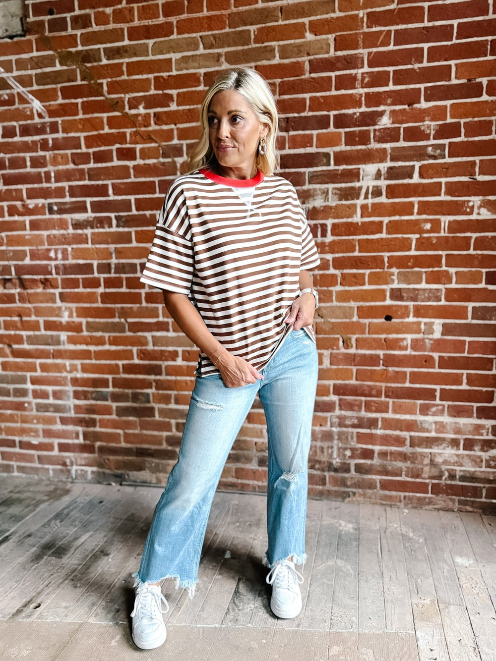 A woman wearing a brown and white striped short sleeve tee with a contrast ribbed neckline.