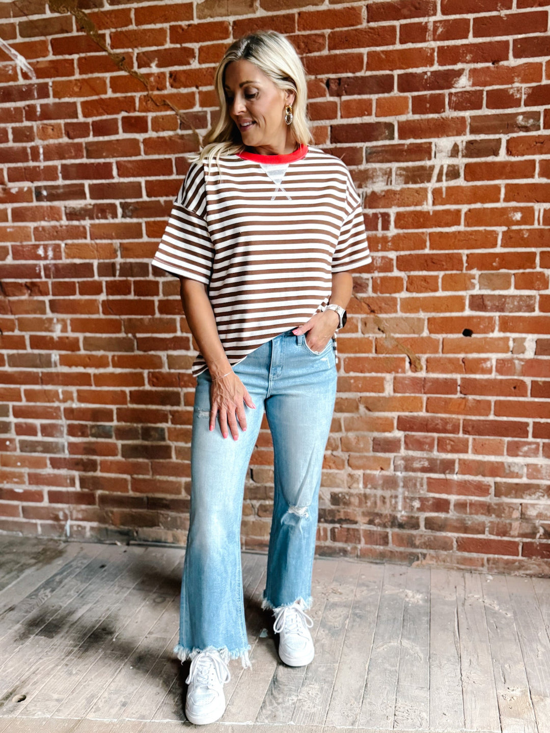 A woman wearing a brown and white striped short sleeve tee with a contrast ribbed neckline.