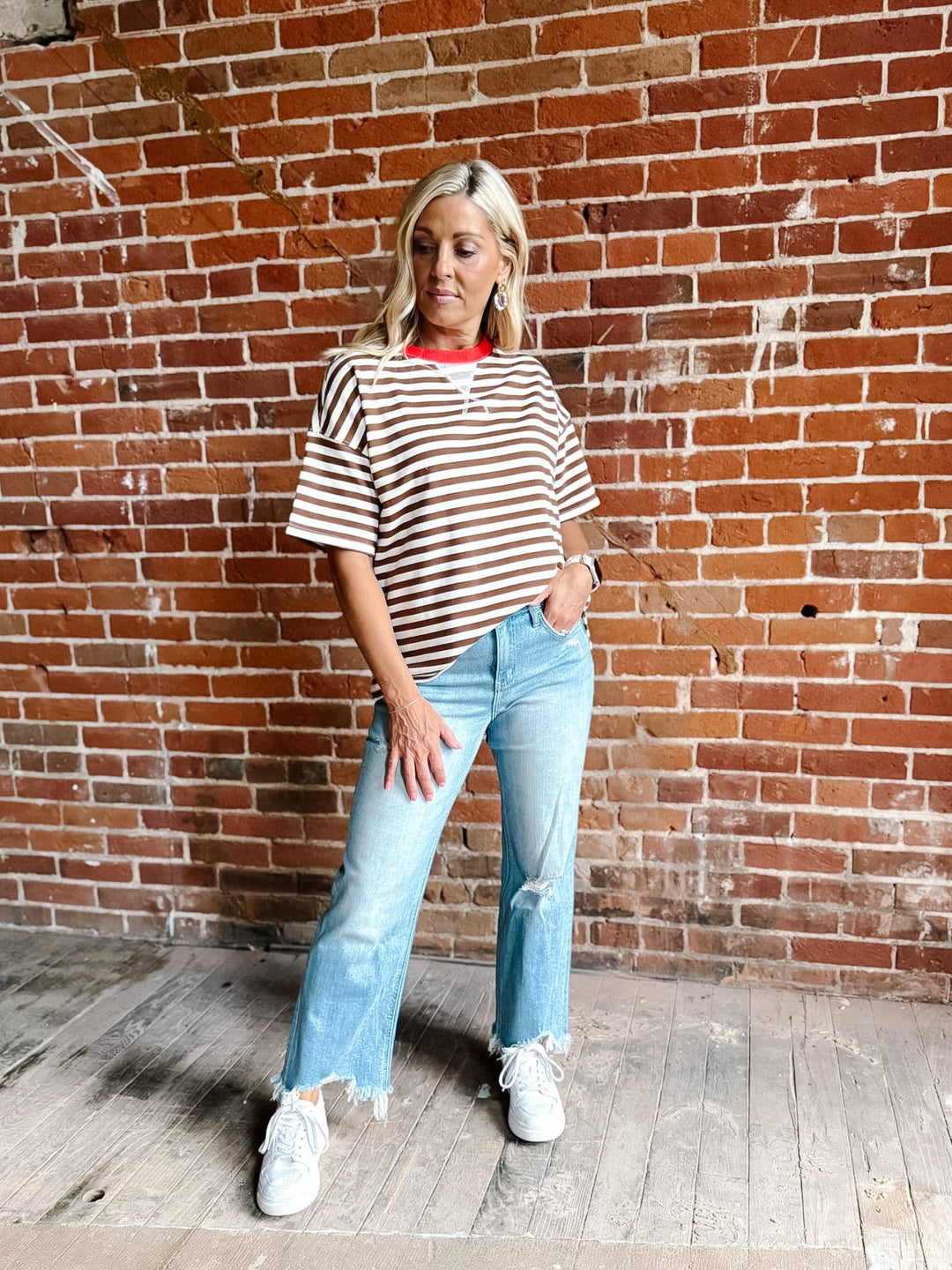 A woman wearing a brown and white striped short sleeve tee with a contrast ribbed neckline.